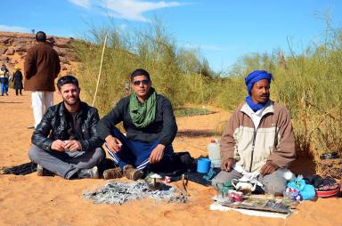 Oussama and I pose net to a desert inhabitant brewing tea in the traditional manner. Taghit.