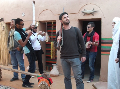 Me posing with a rifle as another tourist displays his guitar skills to admiring friends.  Beni Abbes.