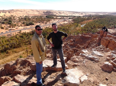 Ahmed and I on a rocky ledge overlooking a palm-strewn valley below. Taghit.