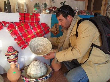 Ahmed demonstrates a traditional woven couscous vessel.